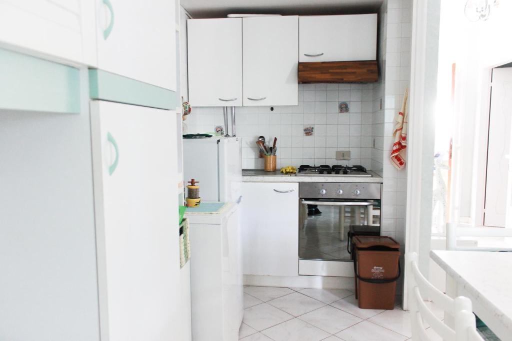 a kitchen with white cabinets and a refrigerator at Lagomare Puccini in Torre del Lago Puccini