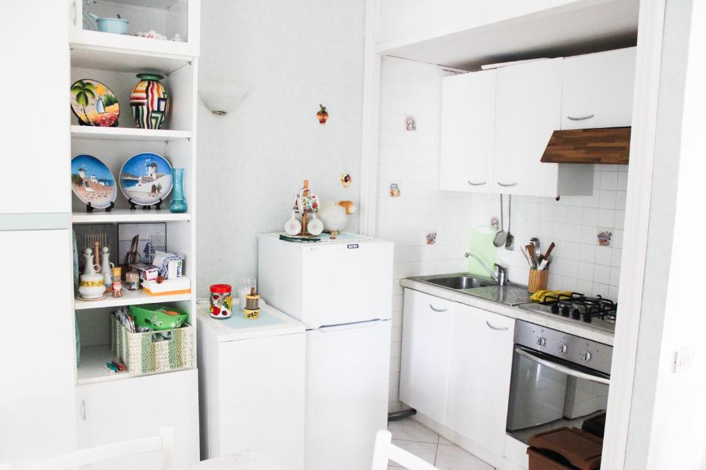 a kitchen with white cabinets and a sink at Lagomare Puccini in Torre del Lago Puccini