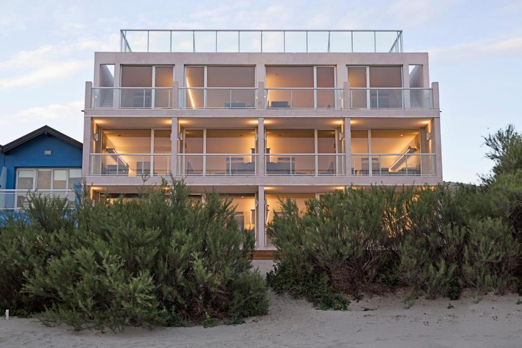 a house on the beach with bushes in front of it at Oceano Patagonia by Nordic in Puerto Pirámides