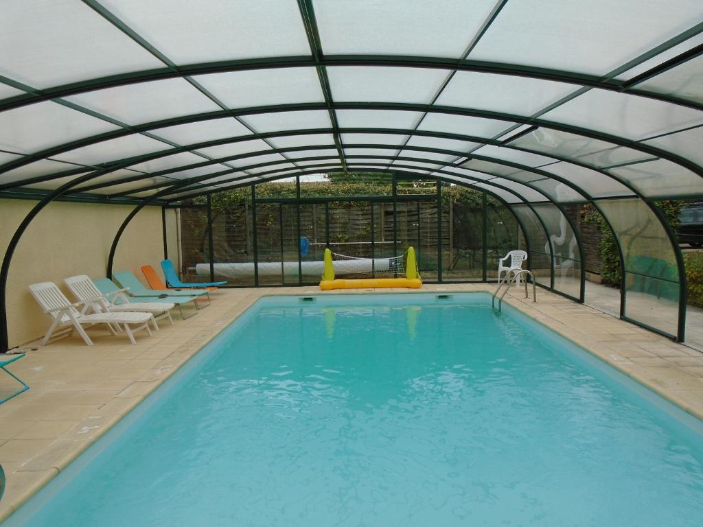 a swimming pool with a retractable roof and a swimming pool at Sans Souci in Cahuzac
