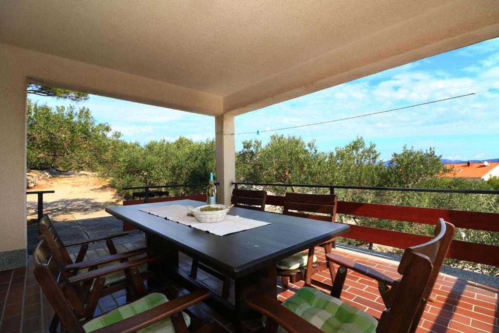 Una mesa y sillas en un balcón con vista. en Apartmani Sladić, en Betina