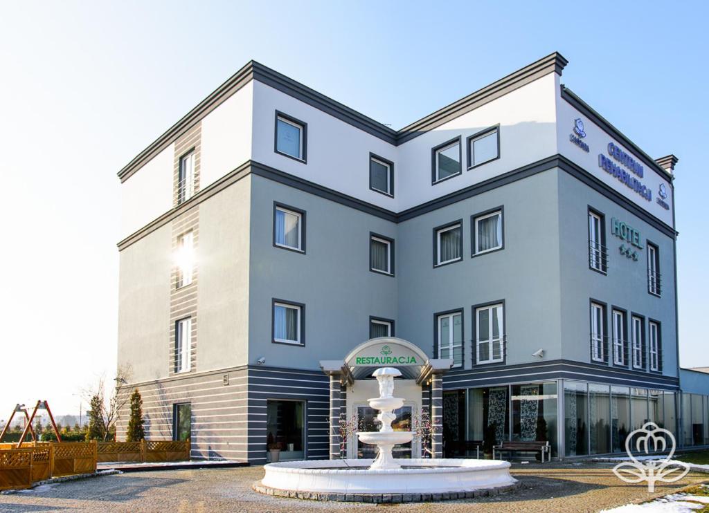 a large building with a fountain in front of it at L'ascada Hotel in Śrem