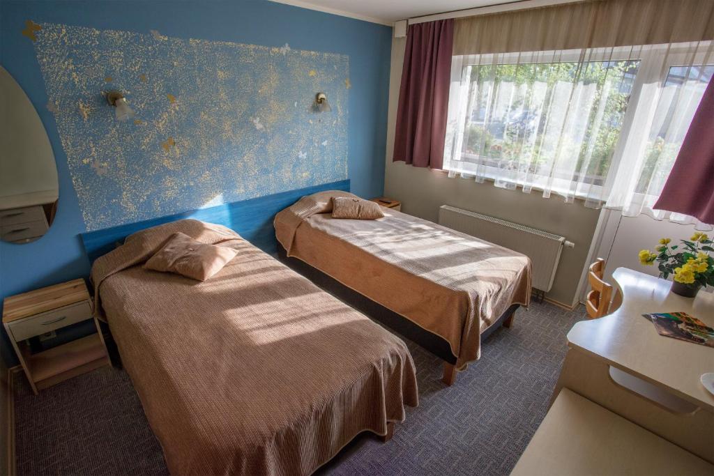 a hotel room with two beds and a window at Endla Hotell in Viljandi