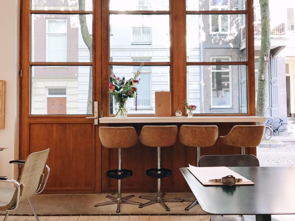 um quarto com uma mesa e cadeiras em frente a uma janela em Hotel Karel em Arnhem