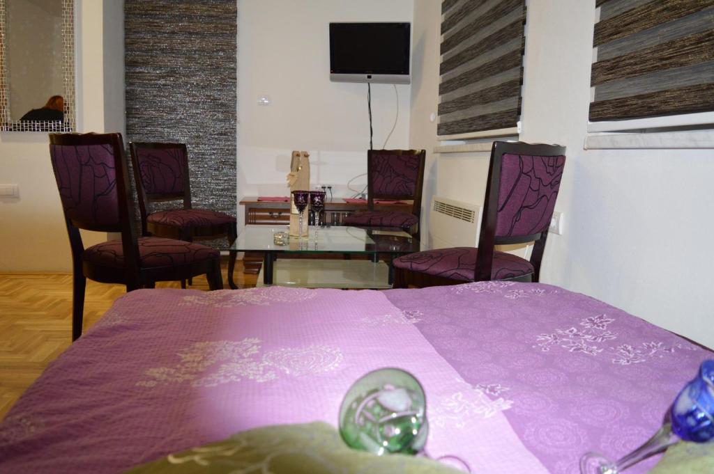 サラエボにあるVilla Stanisicのベッド1台、椅子、テーブルが備わる客室です。