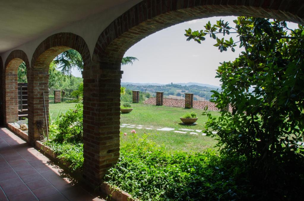 uma vista arcada de um jardim a partir de uma casa em Al Riccio em Cocconato