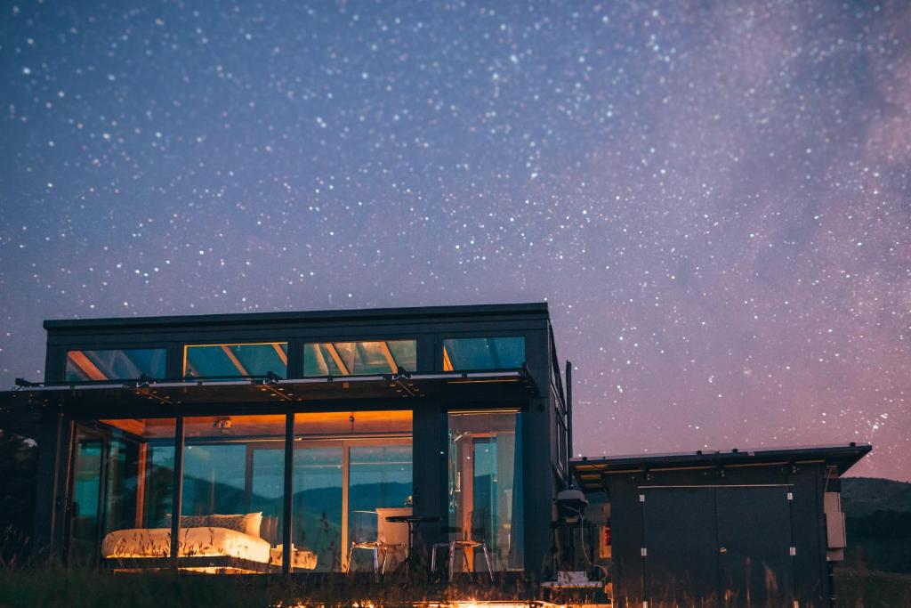 una casa bajo un cielo estrellado con la Vía Láctea en Greystone PurePod en Waipara