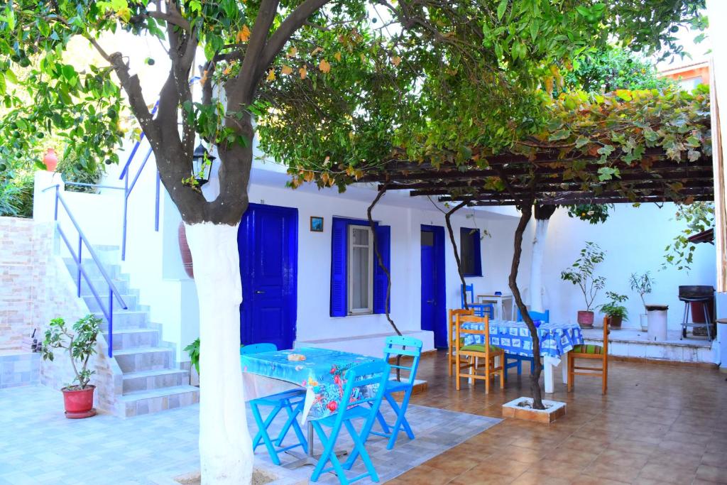een patio met een tafel en stoelen onder een boom bij Stathis in Rhodos-stad
