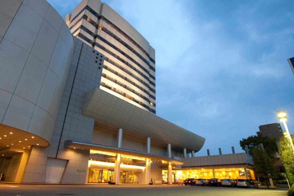 a tall building with lights on in front of it at Kofu Kinenbi Hotel in Kofu