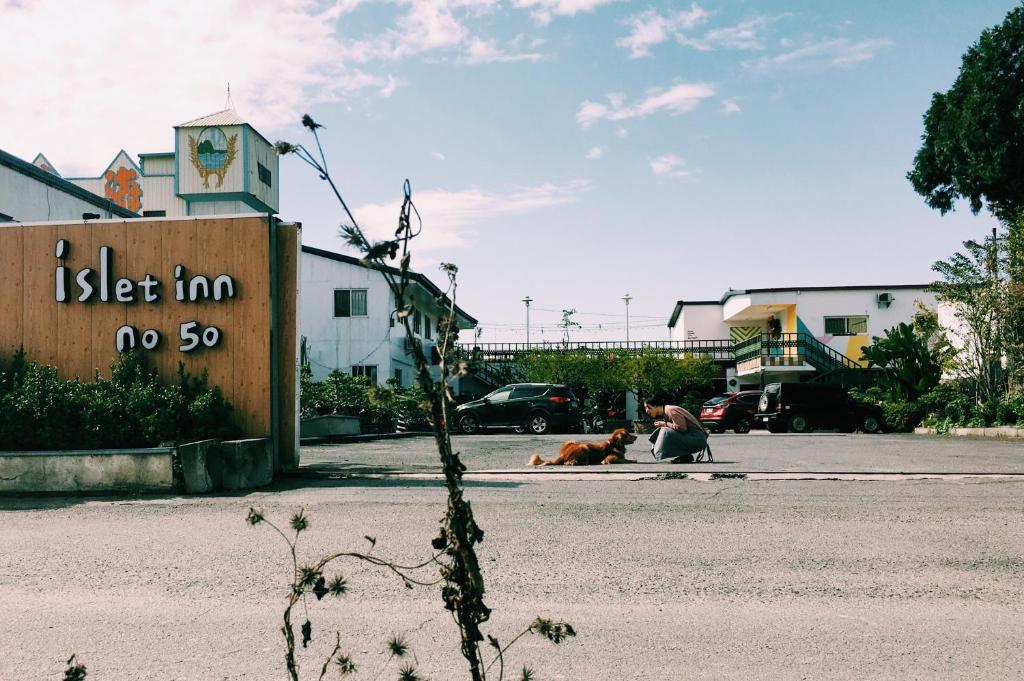 un hombre y un perro sentados en un estacionamiento en Puli Islet Inn en Puli