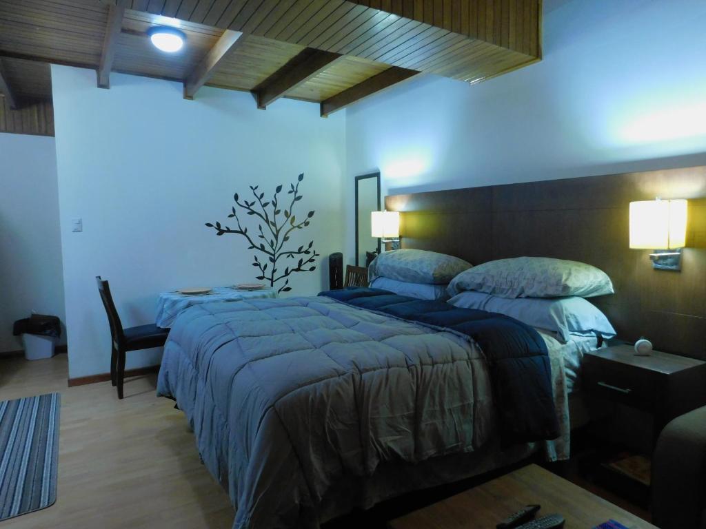 1 dormitorio con 2 camas y pared azul en Modern Studio Loft Apt King Bed 10 min frm airport, en La Asunción