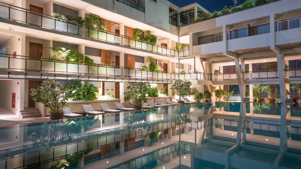 an external view of a building with a swimming pool at Hotel Somadevi Angkor Boutique and Resort in Siem Reap