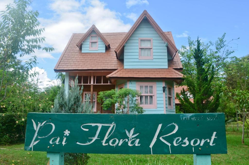 Pai Flora Resort في باي: منزل أمامه لافته