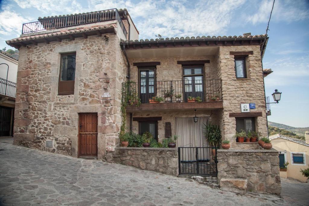 a stone house with a balcony on a street at Ciudad de Verdeoliva in Segura de Toro