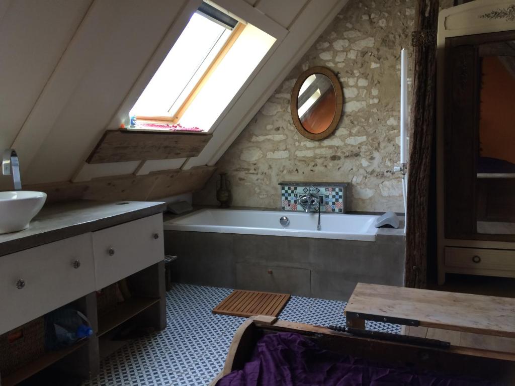 a bathroom with a tub and a sink and a window at Chambre du Toucan in Misy-sur-Yonne