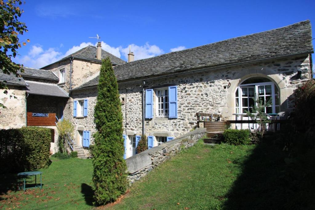 une ancienne maison en pierre avec un jardin en face de celle-ci dans l'établissement La Parenthese insolite, à Saint-Hostien