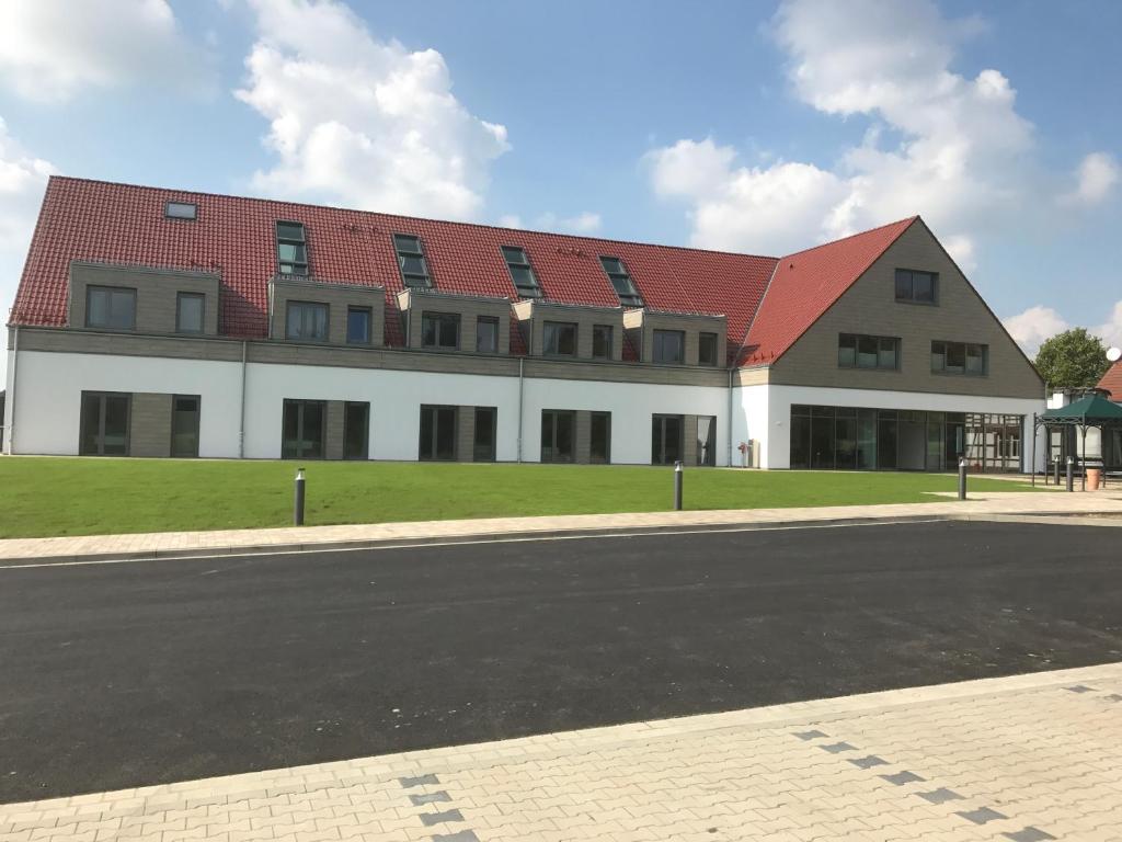 un grand bâtiment avec un toit rouge dans une rue dans l'établissement Hotel Weinhaus Möhle, à Bad Oeynhausen