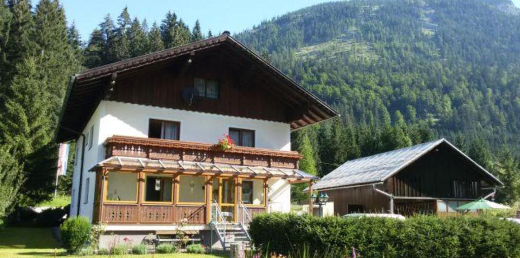 une grande maison avec une montagne en arrière-plan dans l'établissement Ferienresort Gosau, à Gosau