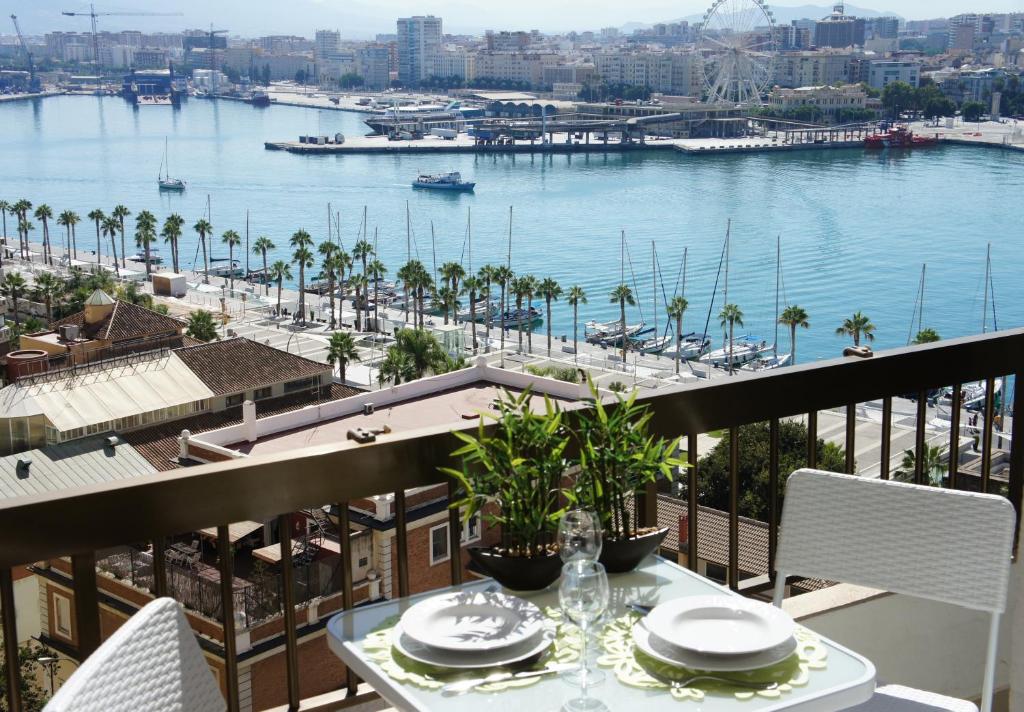 a balcony with a table with a view of a harbor at Malaga Center Flat Exclusive in Málaga