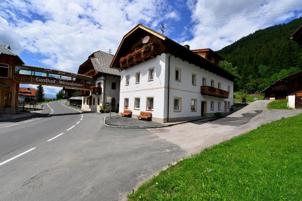 a white building on the side of a road at Haus Kalt in Weissensee
