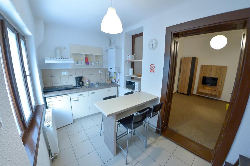 a kitchen with white cabinets and a table and chairs at Apartment Gabriel in Sibiu