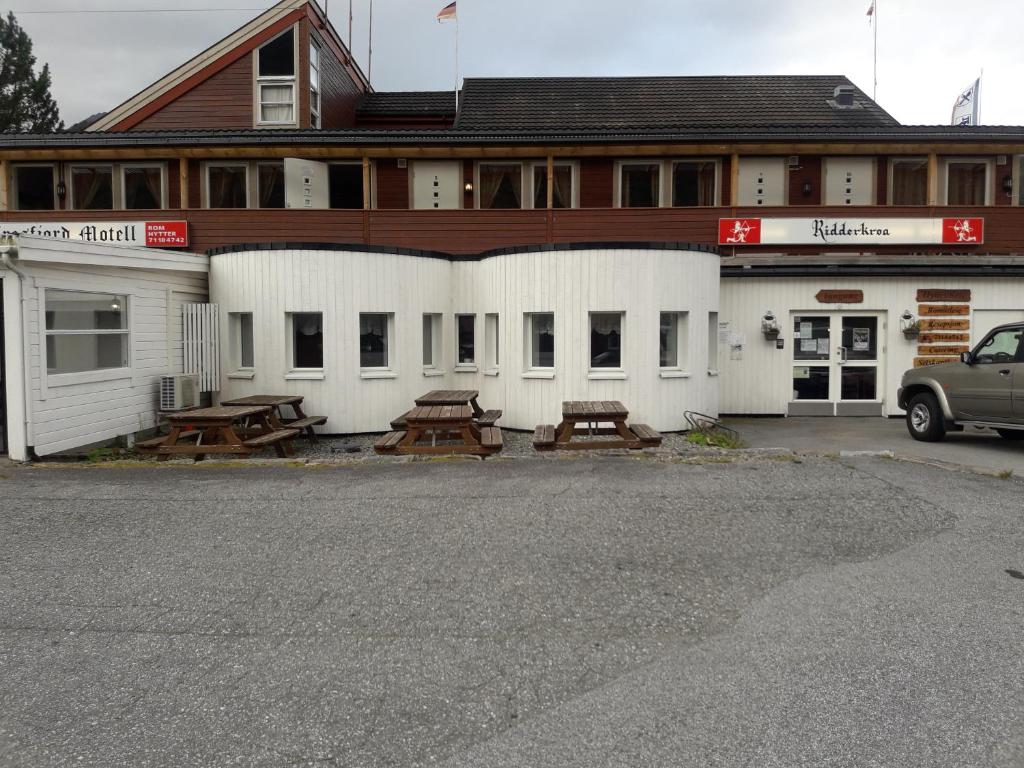 a building with benches and tables in front of it at Ridderkroa Tresfjord in Tresfjord