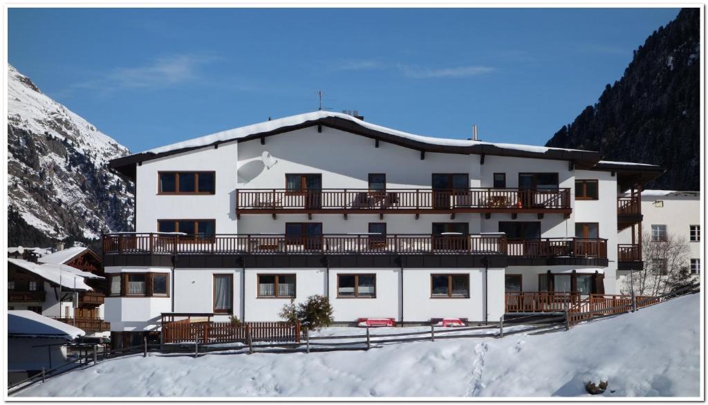 ein großes weißes Gebäude mit Balkon im Schnee in der Unterkunft Haus Soldanella in Vent