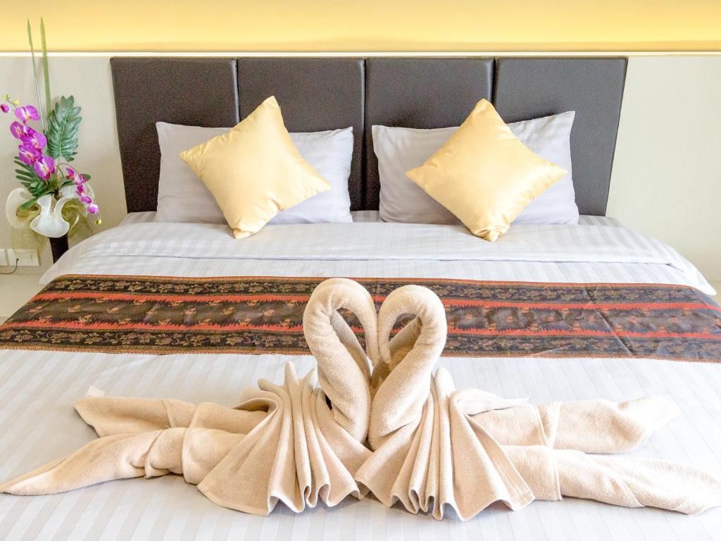 two swans making a heart shape on a bed at Silom Boutique Hotel Hatyai in Hat Yai