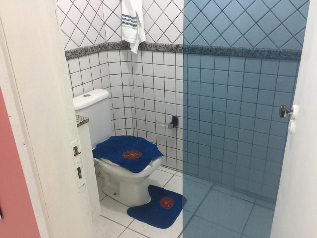 a bathroom with a toilet with a blue tiled wall at Apart Hotel Beira Mar in Maragogi