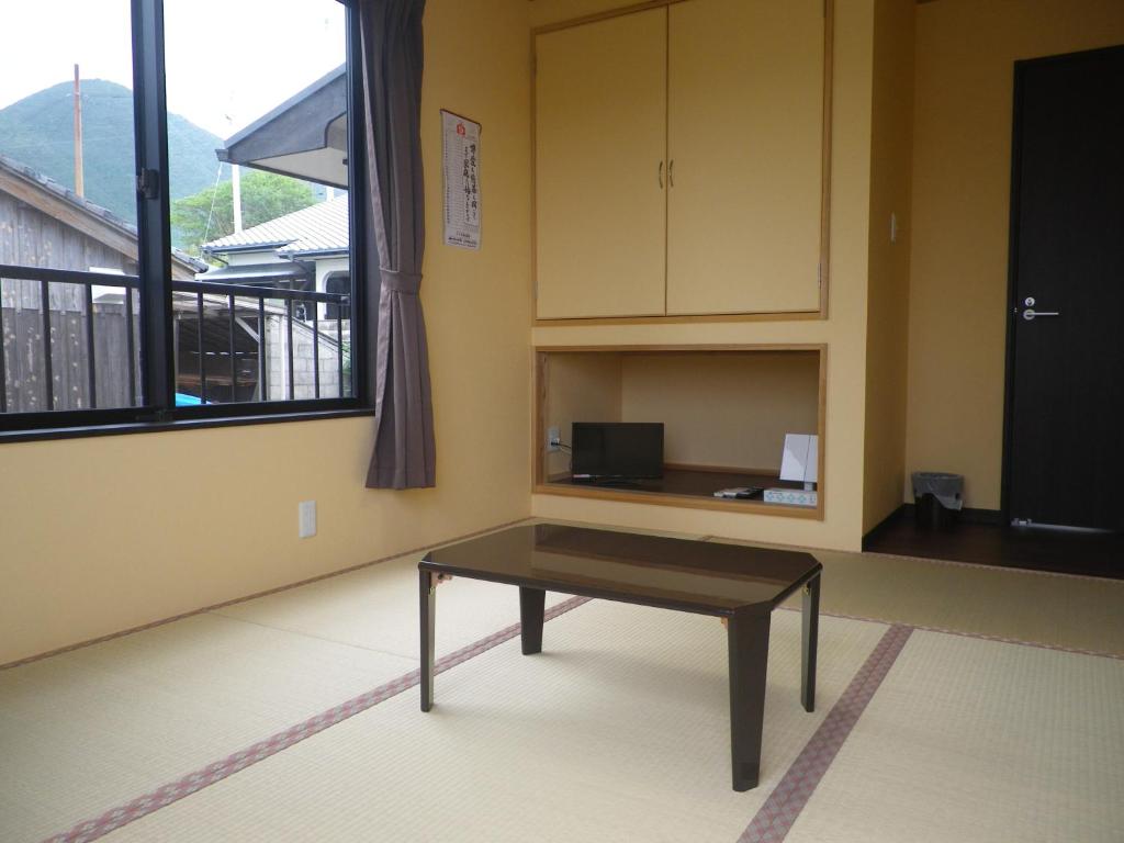 a coffee table in a room with a window at Minshuku Iwakawa in Yakushima