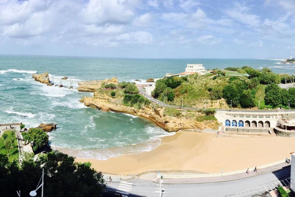 - une vue sur la plage avec un bâtiment et l'océan dans l'établissement AGTBAB, à Biarritz