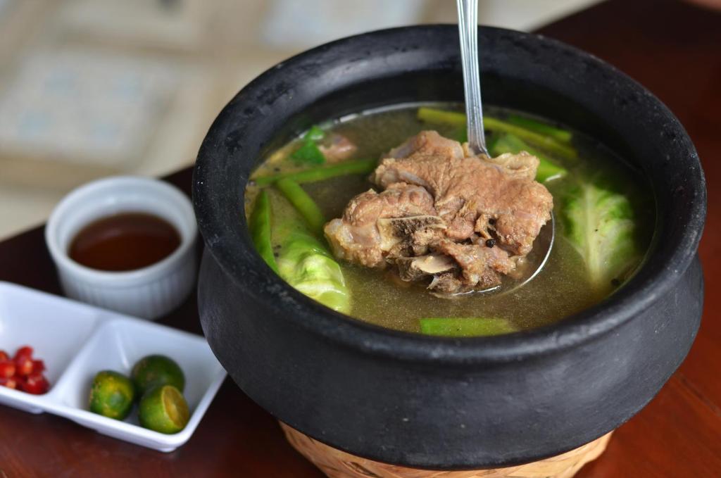 a bowl of soup with a spoon in it at Eagle Point Beach and Dive Resort in Mabini