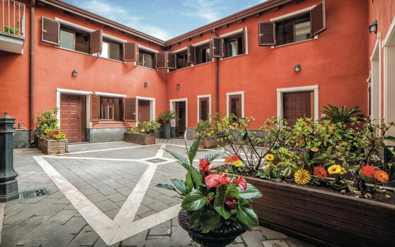 a building with a bunch of flowers in a courtyard at Cortile dei Sogni in Catania