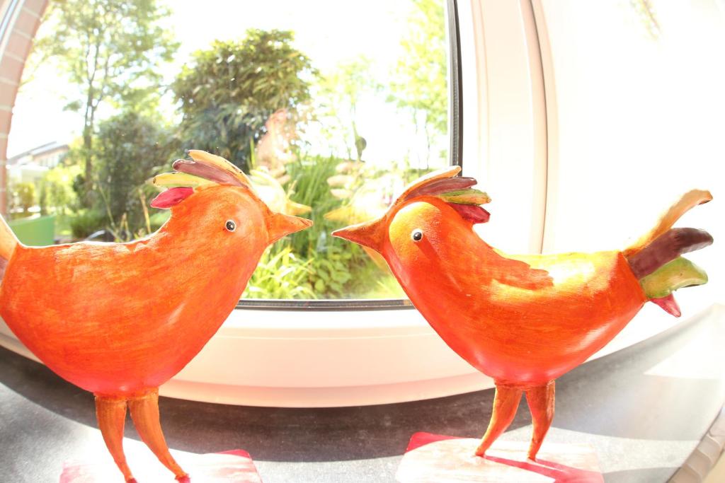 due polli di gomma seduti davanti a una finestra di Haus Wattenloeper a Cuxhaven