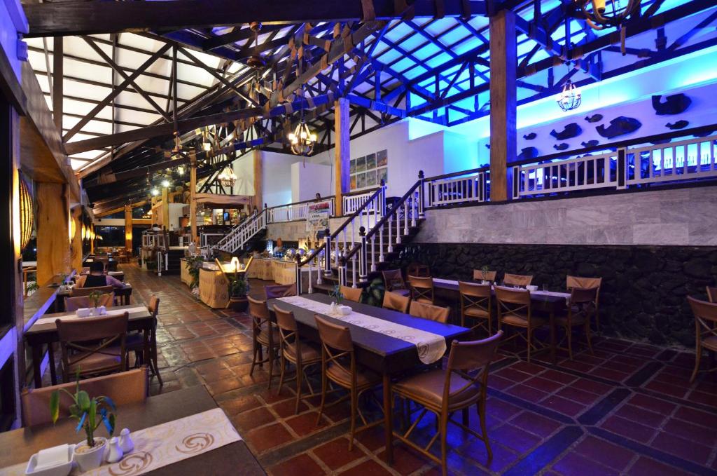 a restaurant with tables and chairs and a staircase at Eagle Point Beach and Dive Resort in Mabini