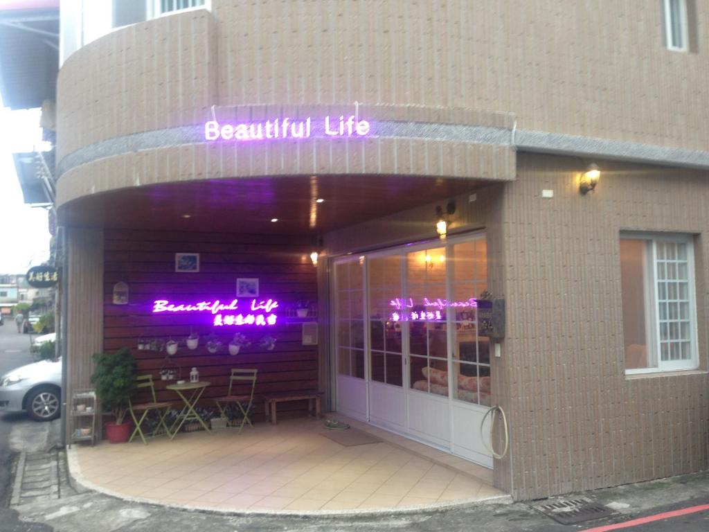 a restaurant with purple signs on the front of a building at Beautiful Life B&amp;B in Dongshan