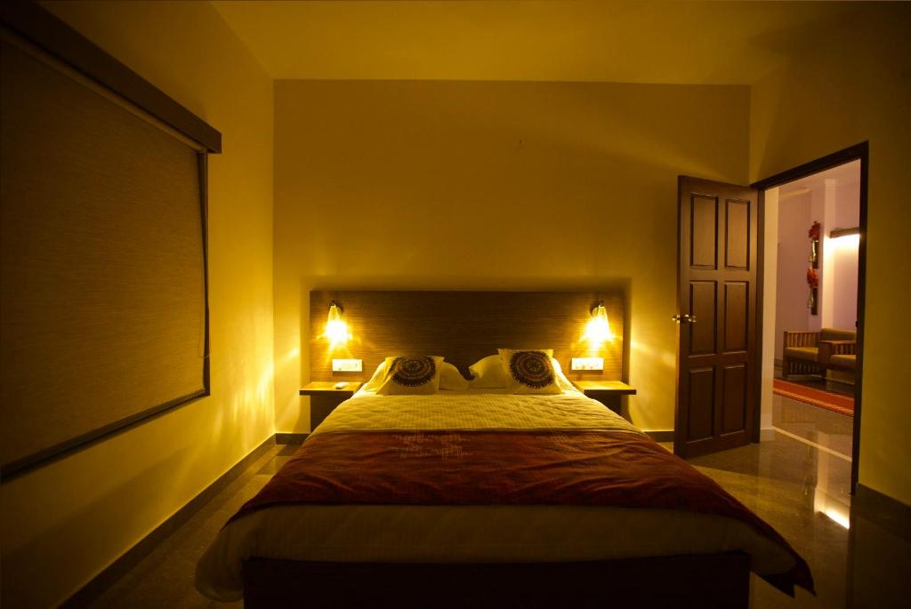 una camera da letto con un grande letto con due lampade sopra di Anchorage Serviced Apartments a Cochin