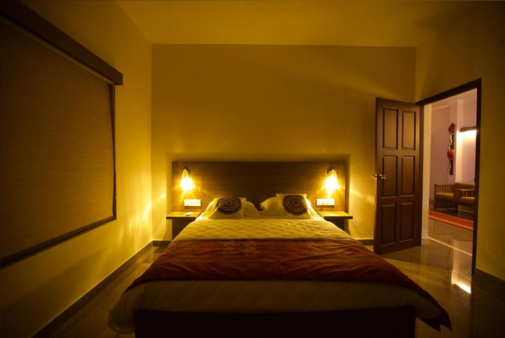 a bedroom with a large bed with two lamps on it at Anchorage Serviced Apartments in Cochin