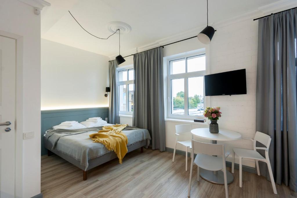 a hotel room with a bed and a table and chairs at 9010 Apartments in Vilnius