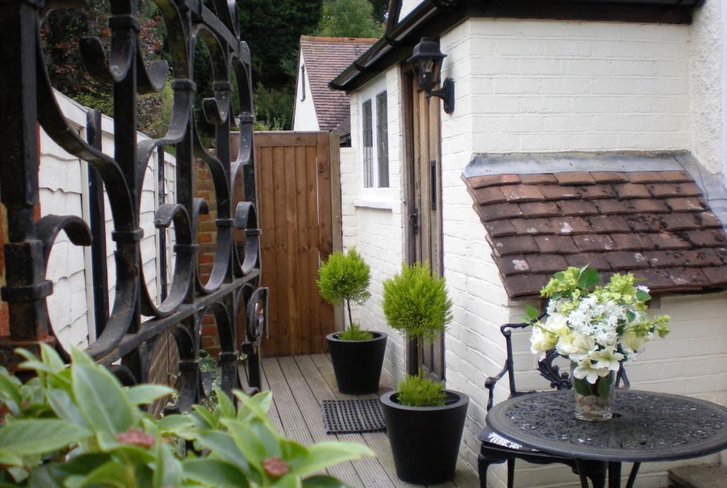 a patio with potted plants and a fence at Rural House near Bramley in Guildford