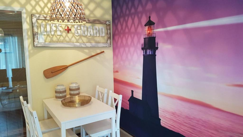 une salle à manger avec une table et une fresque murale représentant le phare dans l'établissement the Lighthouse, à Hollum