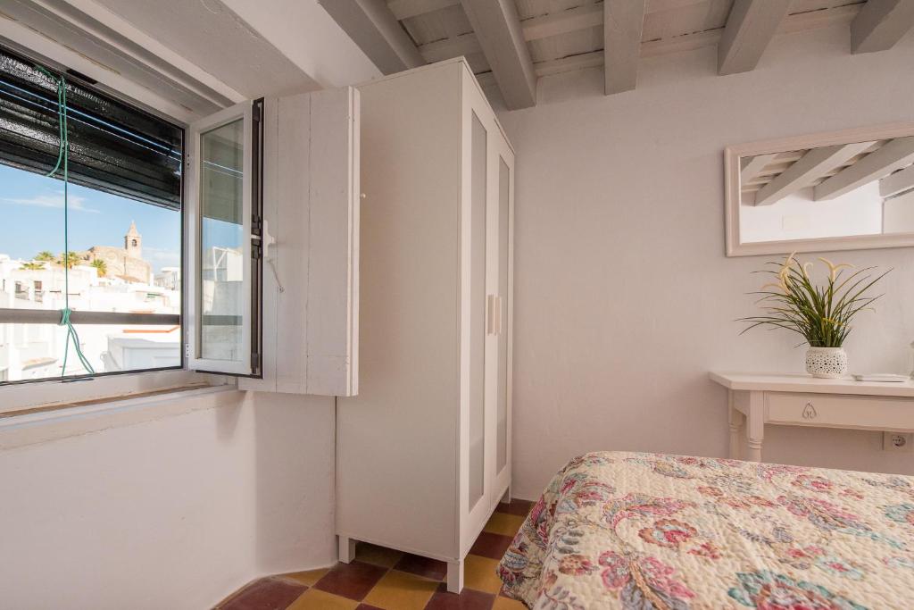 ベヘール・デ・ラ・フロンテーラにあるCasa Calle Altaのベッドルーム(ベッド1台、窓付)