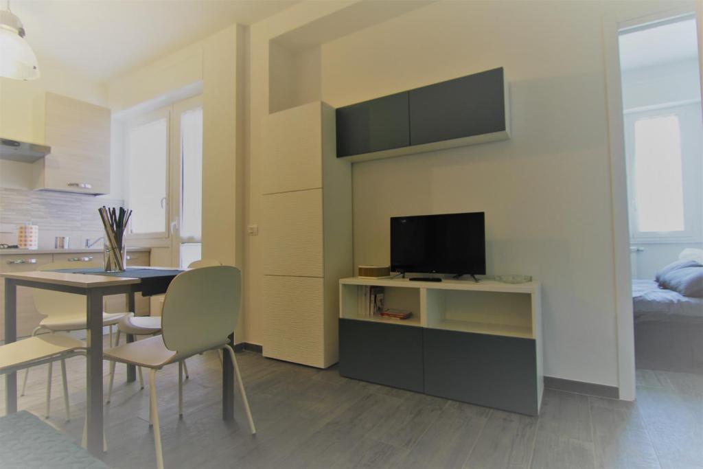ein Wohnzimmer mit einem Esstisch und einem TV in der Unterkunft Appartamento Zona Torregalli_Nuvola Rossa in Florenz