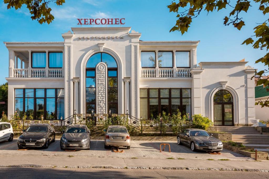 a building with cars parked in front of it at Apartments Hersones in Sevastopol