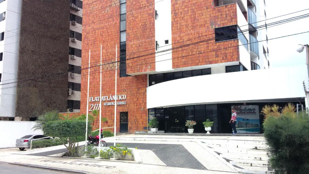 a person standing in front of a brick building at Atlantico Residence Beira Mar in Fortaleza