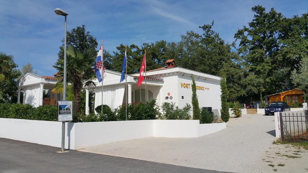 a white building with two flags on top of it at Residence Vogt in Poreč