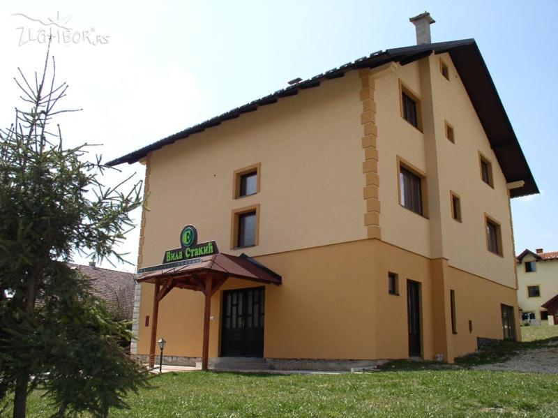 um grande edifício amarelo com um sinal nele em Guesthouse Vila Stakic em Zlatibor