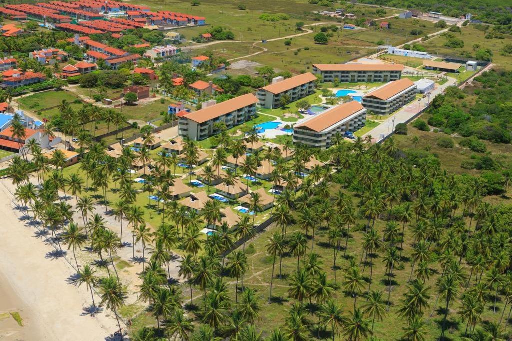 an aerial view of a resort with a beach and palm trees at Carneiros Beach Resort - Flat 2 Quartos in Tamandaré