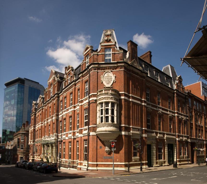 un gran edificio de ladrillo rojo con un reloj. en Hotel du Vin Birmingham en Birmingham