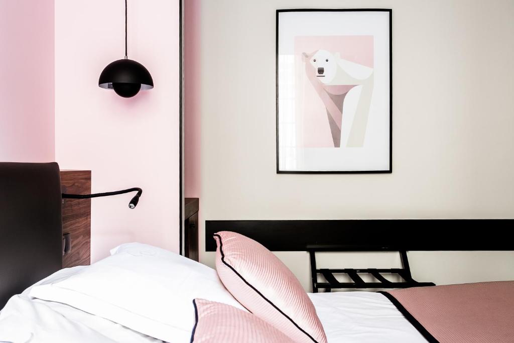 a bedroom with a bed and a picture of a toothbrush at Hostellerie Du Chapeau Rouge in Dijon